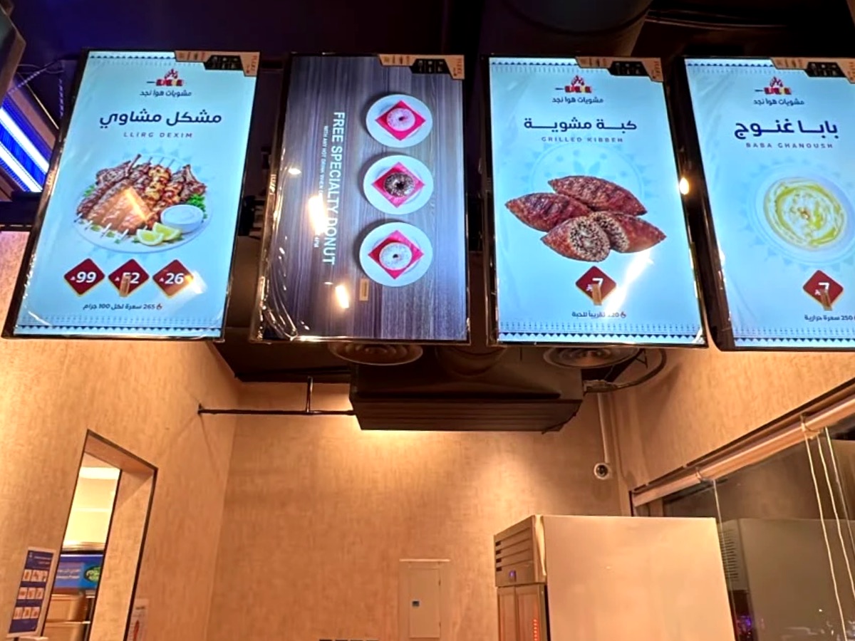 أربع شاشات منيو رقمية بالطول معلّقة فوق كاونتر مطعم